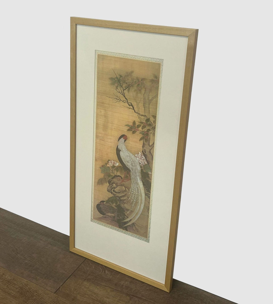 2. "Vertical framed print by Reperch with a bird on a flowering branch, displayed against a wall."