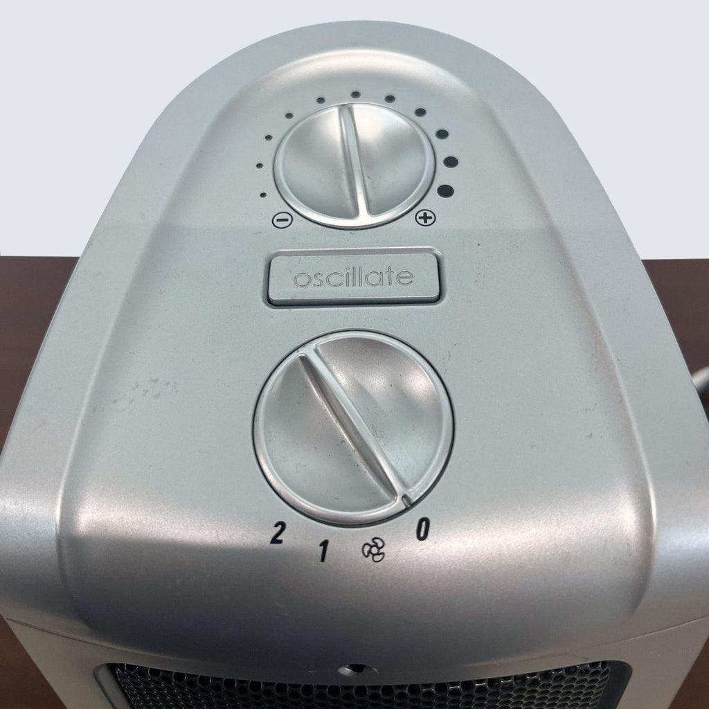Close-up of Lasko ceramic heater controls, showcasing adjustable thermostat and oscillation toggle.