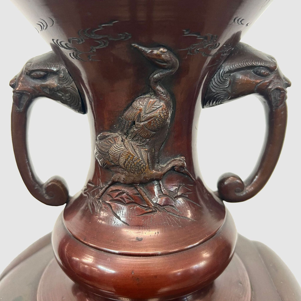 a large chinese bronze vase with two birds on the top