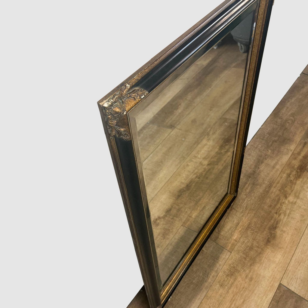 Wall mirror with a beveled design and decorative bronze-gold frame.