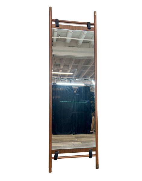 The Beau floor mirror by Article features a walnut frame with leather straps and brass hardware.