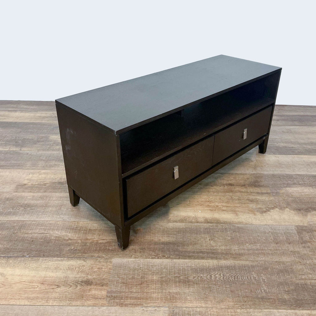 Angled view of a West Elm entertainment center with a dark finish, showcasing its design and legs.