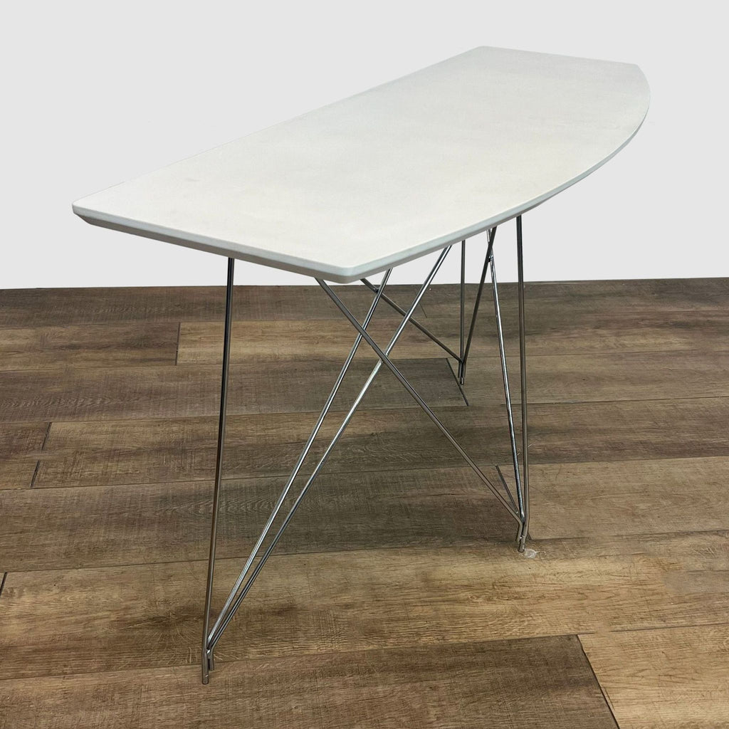 Angled view of a Reperch side table with a white oval top and slender metal legs, positioned on a wooden floor.