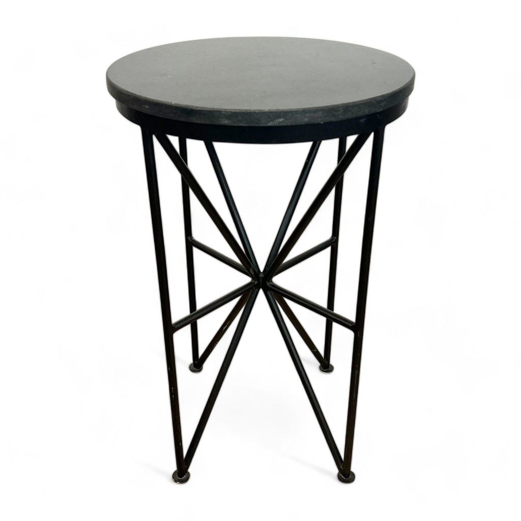 Round black Reperch side table with geometric metal base isolated on white.
