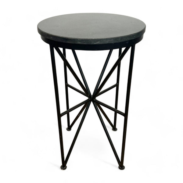 Round black Reperch side table with geometric metal base isolated on white.