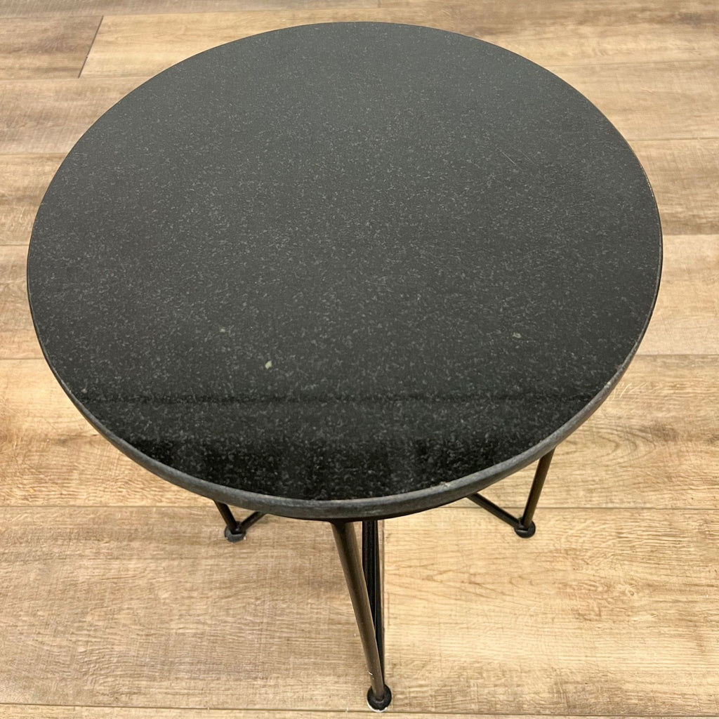Top view of Reperch's round side table, showing textured black surface and slim frame.