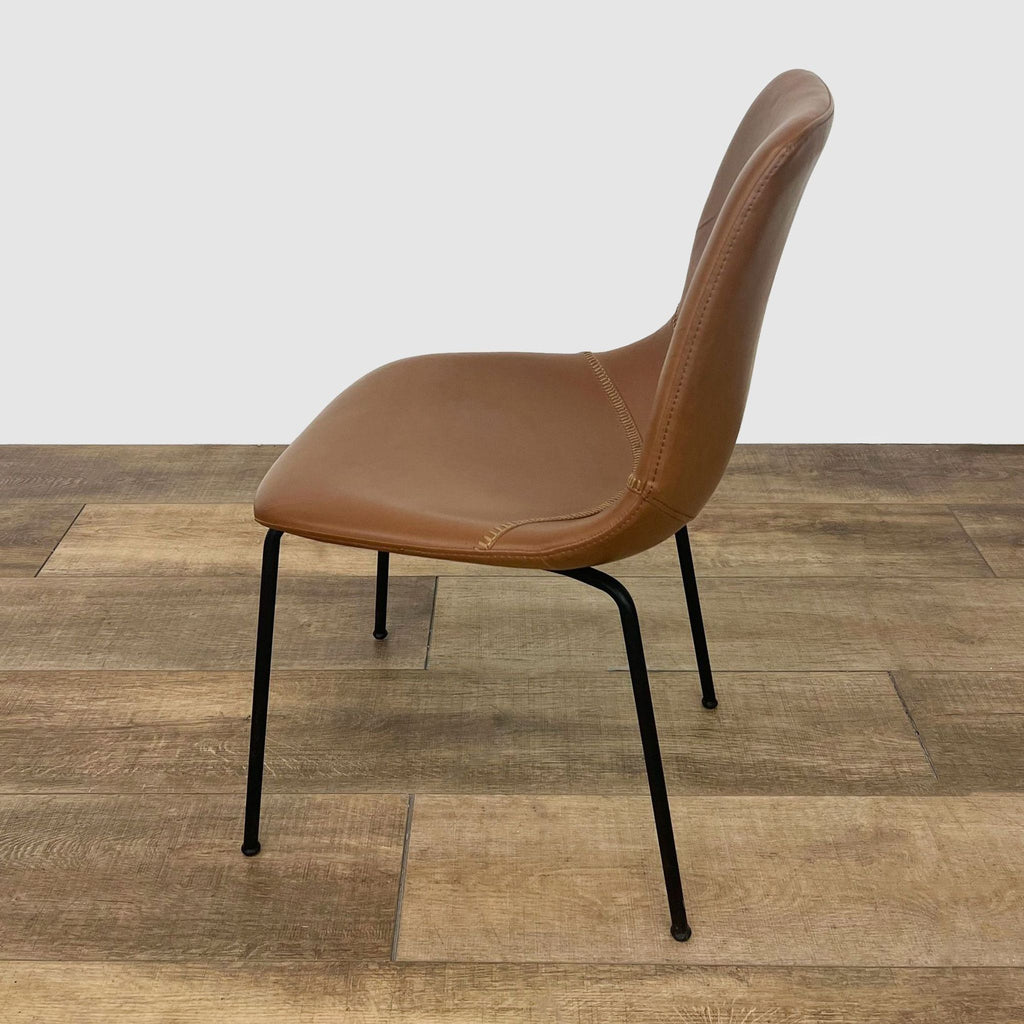 2. Side view of a Reperch brown faux leather upholstered dining chair with elegant stitching and black metal legs.