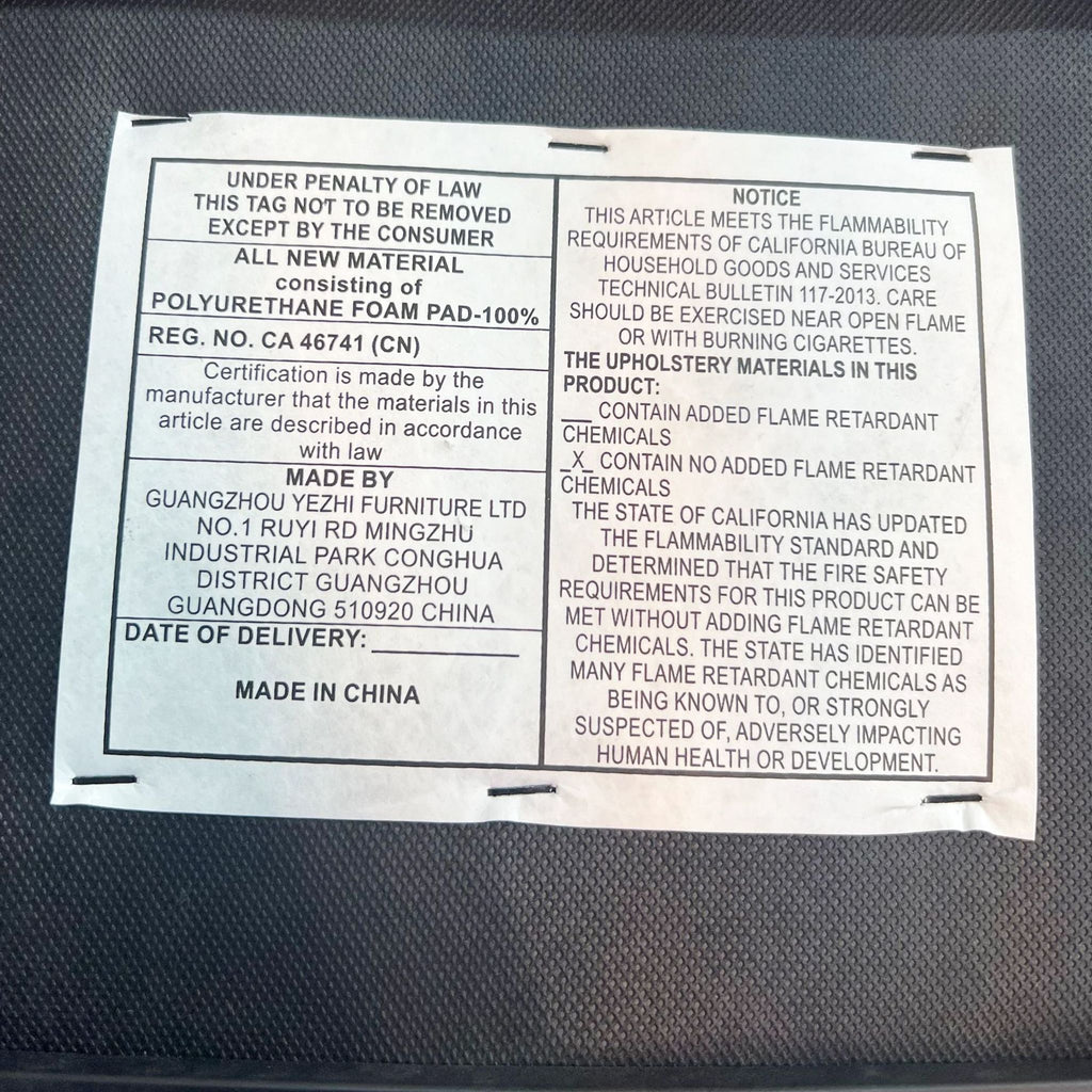 3. Close-up of a label on a Reperch dining chair showing safety and manufacturing details, with a note about flame retardant chemicals.