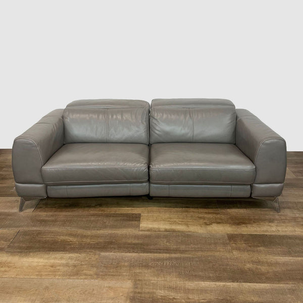 Grey leather upholstered Reperch loveseat with metal feet on wooden floor.