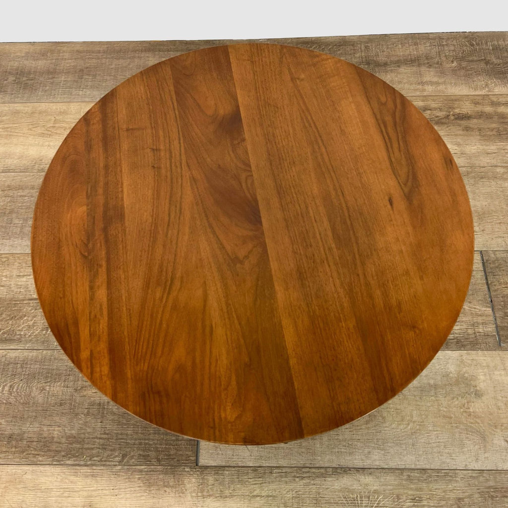 Top view of AllModern Wadsworth coffee table, showcasing the round solid walnut wood surface and black base edges.