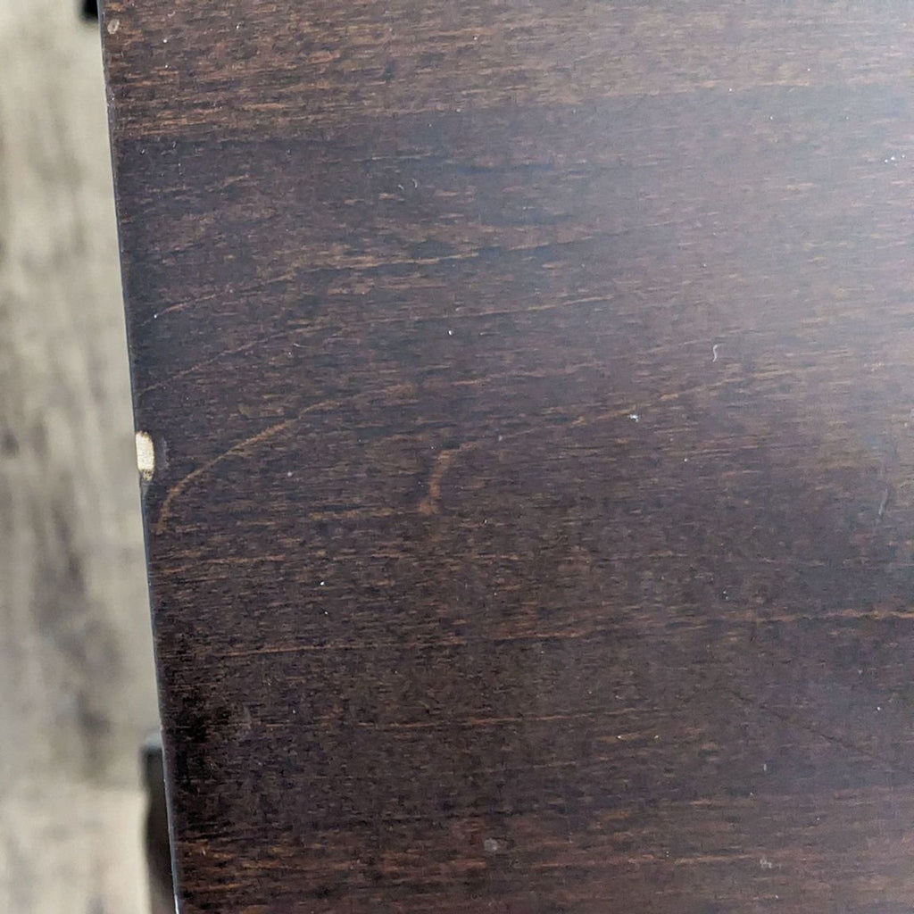 3. Close-up of the wood grain and texture on the surface of a Baronet Furniture end table showing signs of wear.