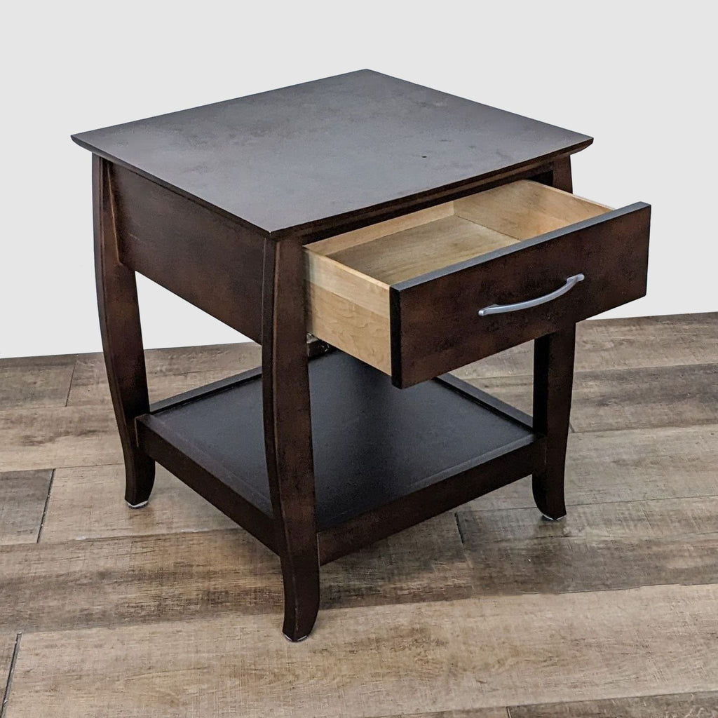 2. Angled view of a Baronet Furniture end table with an open drawer revealing light wood interior, against a wood floor background.