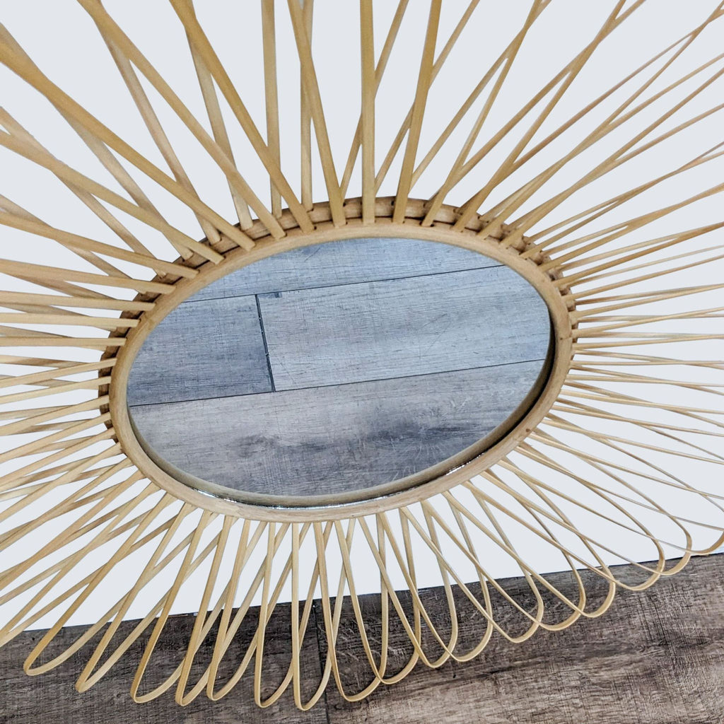 2. "A close-up view of the CB2 Mick wall mirror showcasing the intricate weave of bamboo and rattan around the reflective glass."