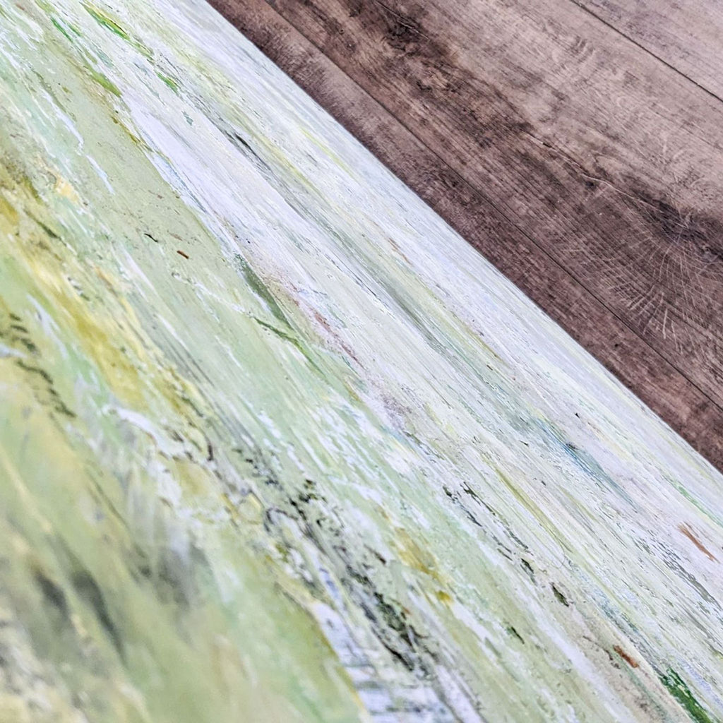 Close-up on textured Giclee canvas art displaying soft, blended hues of white, green, and yellow tones.