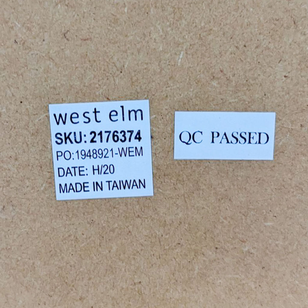 Back of a West Elm rectangle mirror showing brand label and a 'QC Passed' sticker, indicating quality control approval.