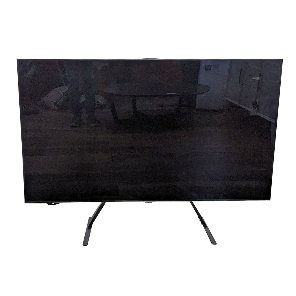 Samsung flat-screen TV off, modern design, on a stand in a living space.