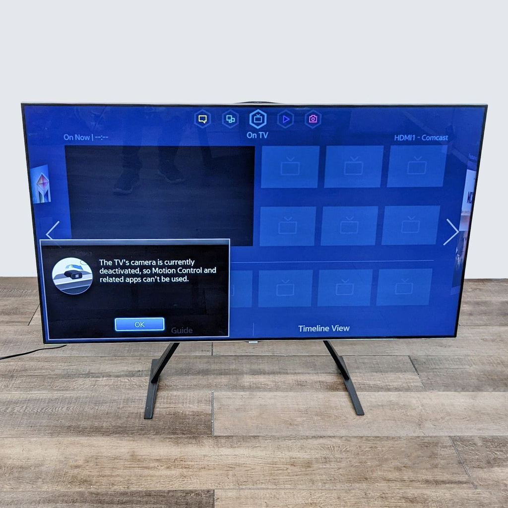 Samsung smart TV displaying a deactivated camera message, on a wooden floor.
