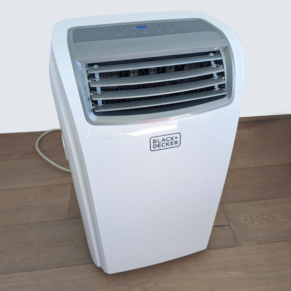 2. Black + Decker portable air conditioning unit on a wooden floor with a digital display on top.