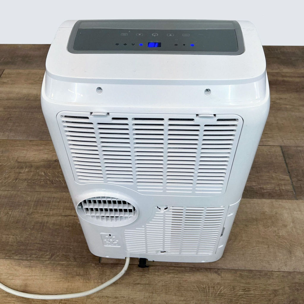 3. Rear view of a Black + Decker portable AC unit showing the venting grid and cord on a wooden floor.