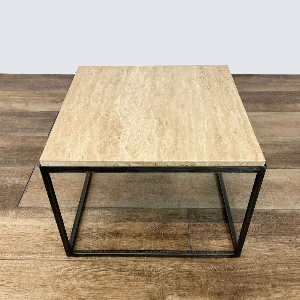 3. Minimalist Reperch coffee table with a light wood finish top and geometric black metal base, viewed from above on a wooden floor.