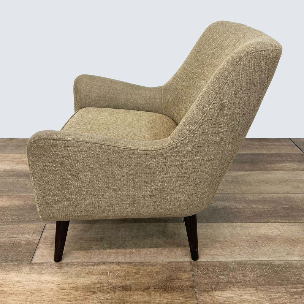3. Room & Board's Quinn chair in profile view highlighting its curved lines and mid-century style on a wood floor.