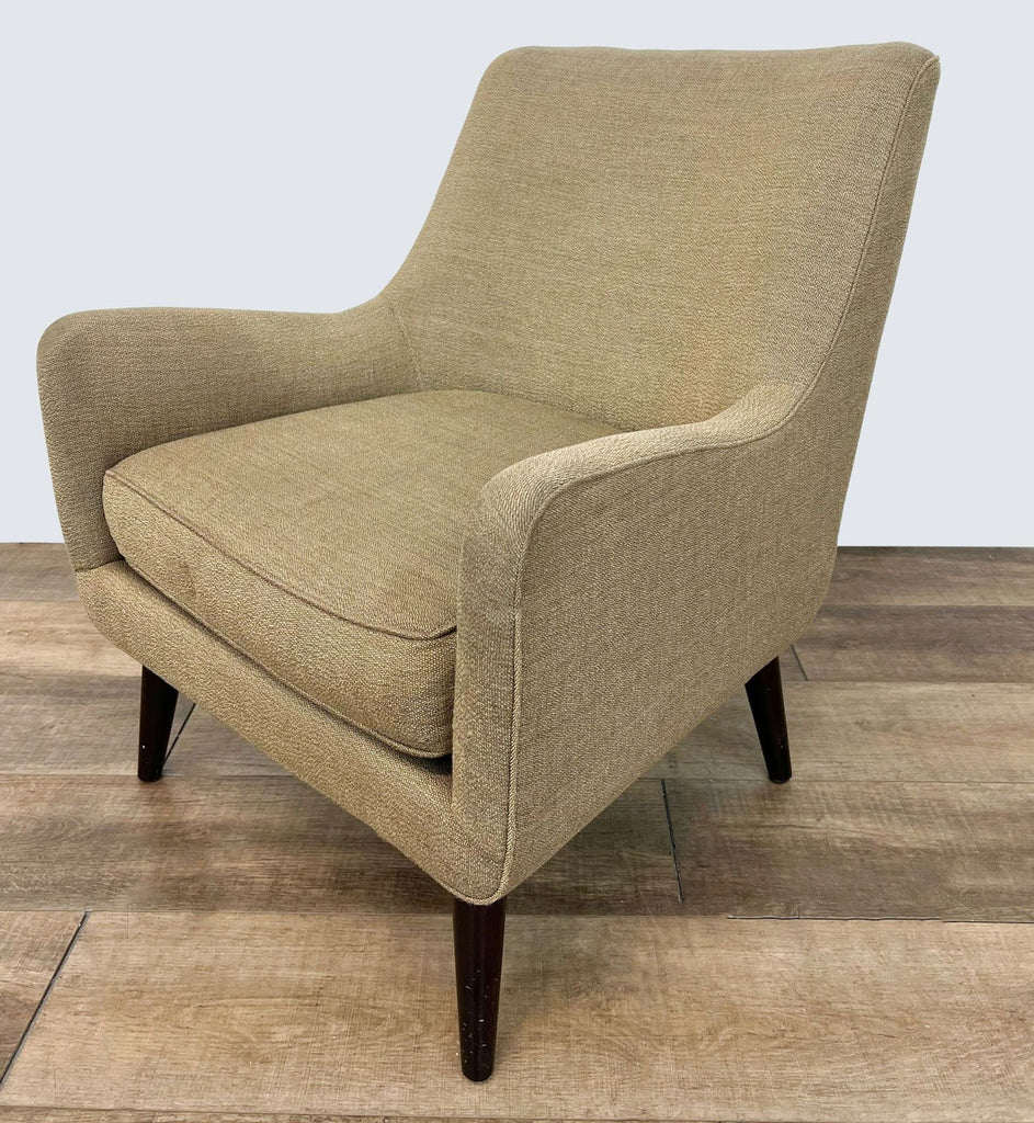 2. The Quinn lounge chair by Room & Board, shown from an angle, featuring a woven fabric and mid-century design.