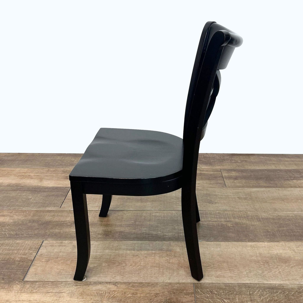 2. "Side view of a black painted, solid wood Vintner side chair by Crate & Barrel with hand-rubbed edges for a used look."