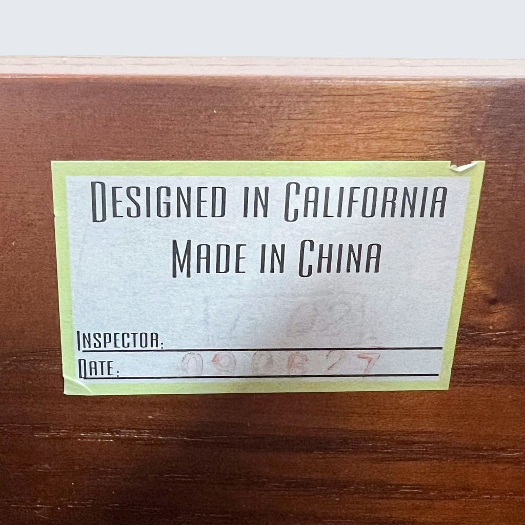 3. Close-up of a label stating "Designed in California, Made in China" on a wooden desk.