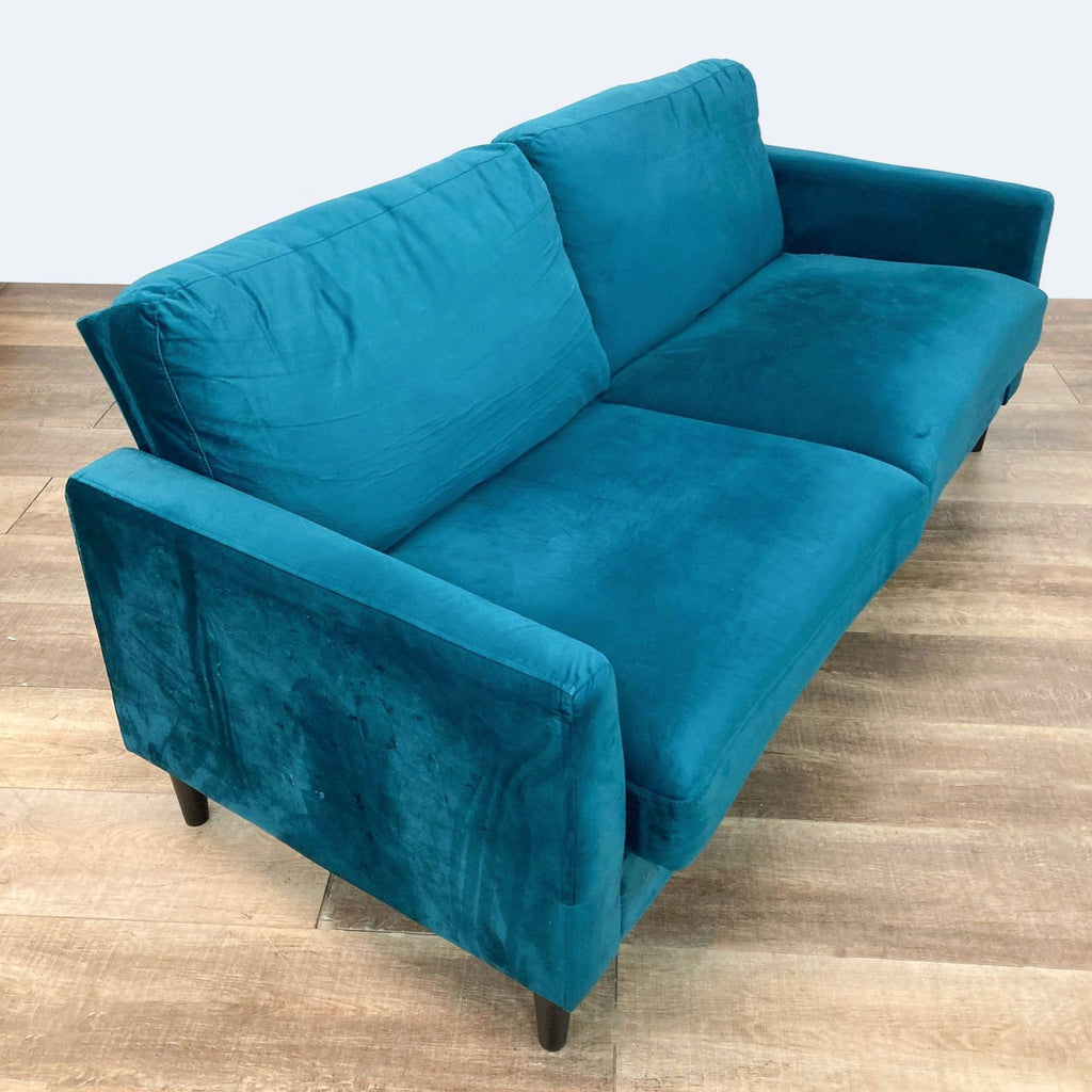 2. Angled view of the Winston Loveseat, showing the velvet upholstery and side profile with wood frame.