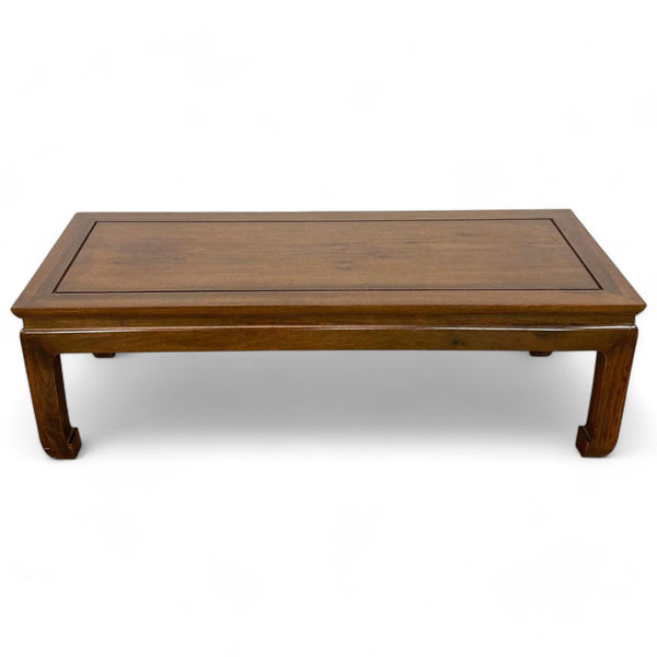Reperch wooden coffee table with a sleek design and curved legs.