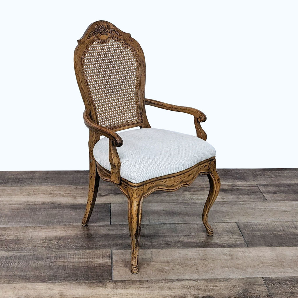 3. Antique Reperch Louis XV style armchair showcasing its cane back and plush upholstered seat, set against a wooden floor backdrop.