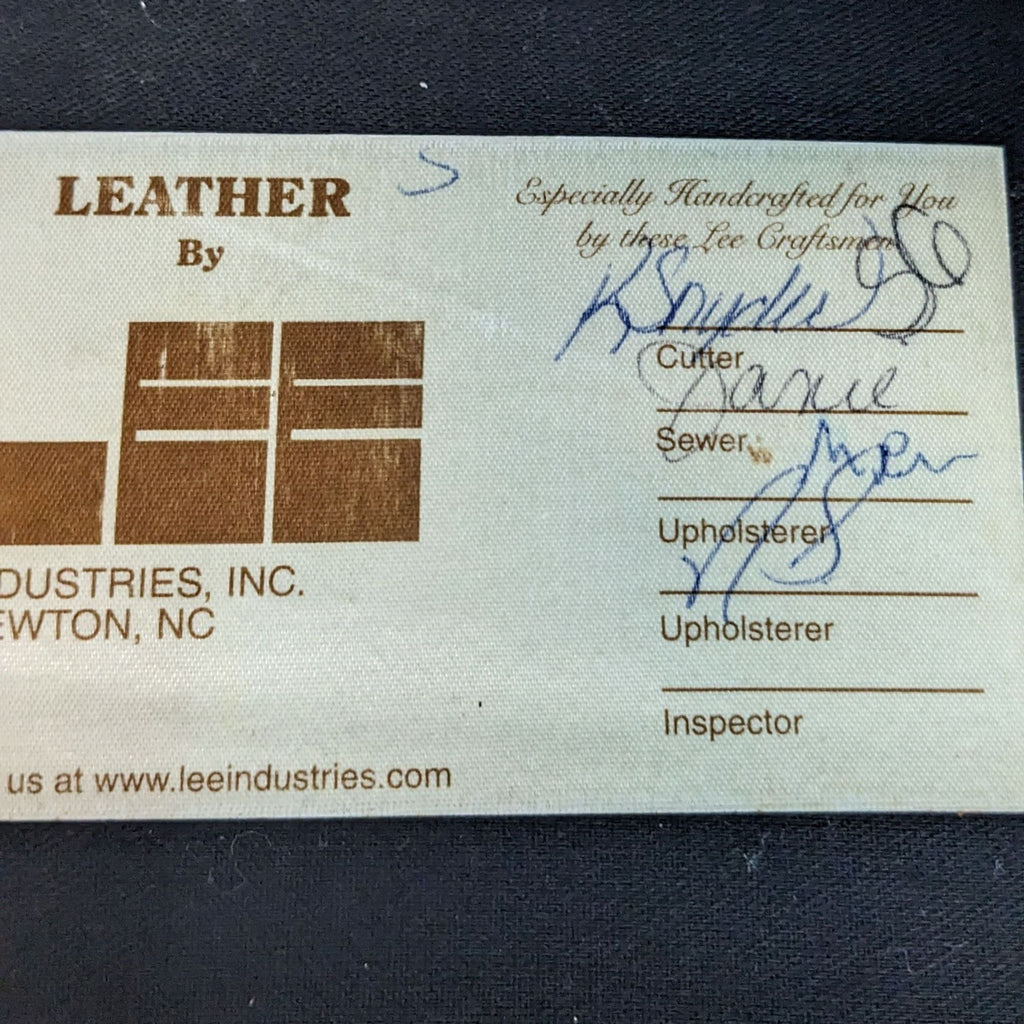 Close-up of a Lee Industries label on leather furniture, showing signatures of craftspeople and brand details.