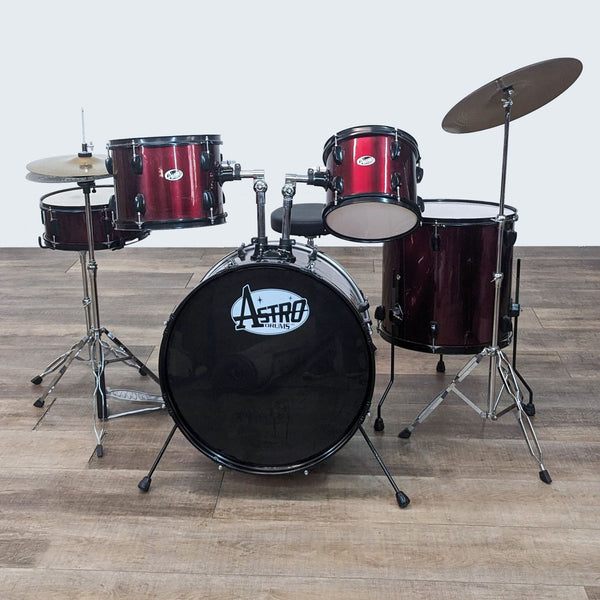 1. A 5-piece Astro Drums kit in wine red finish, including snare, toms, and bass drum with cymbals on a wooden floor.