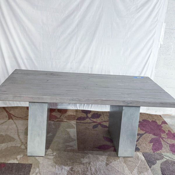 Restoration Hardware dining table with reclaimed French oak planks and concrete slab legs.