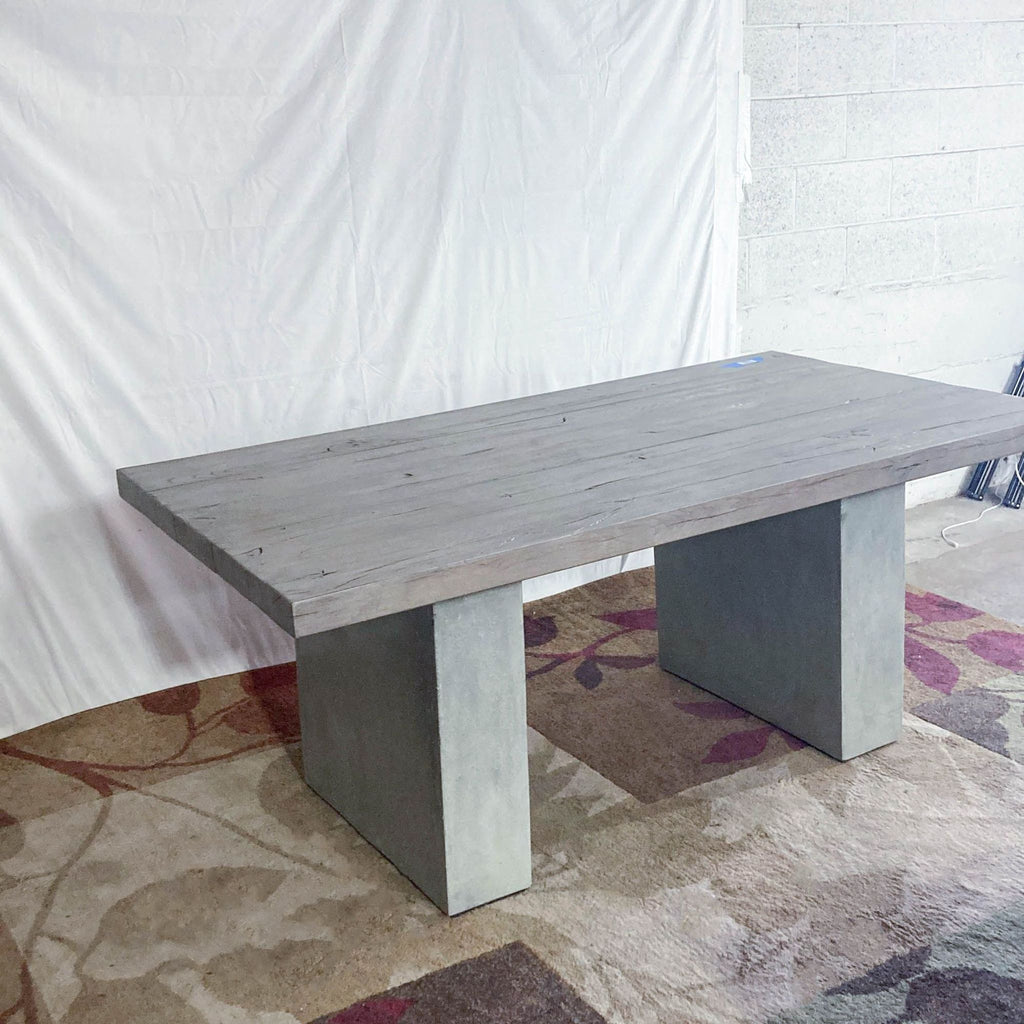 Dining table by Restoration Hardware showcasing a thick French oak top and sturdy concrete supports.