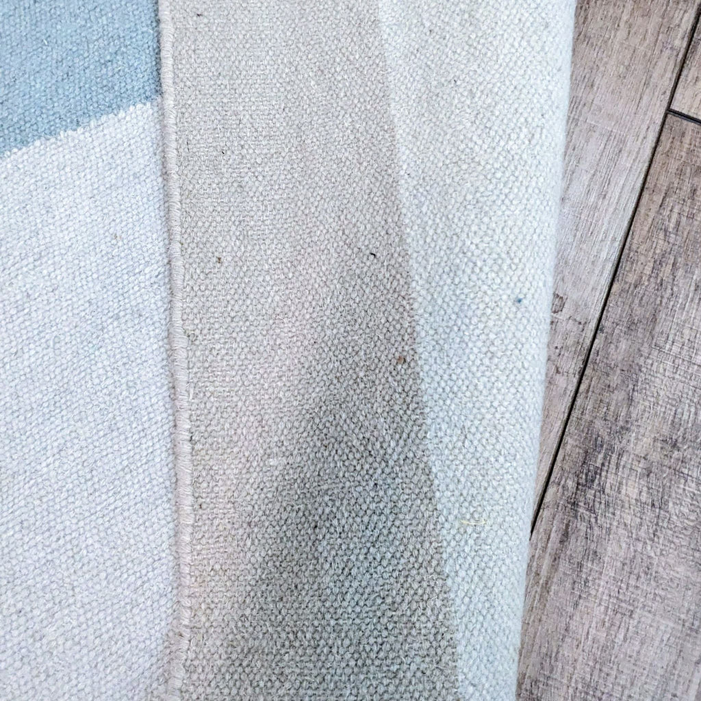 Close-up of the handwoven wool texture on EQ3's dhurry rug.