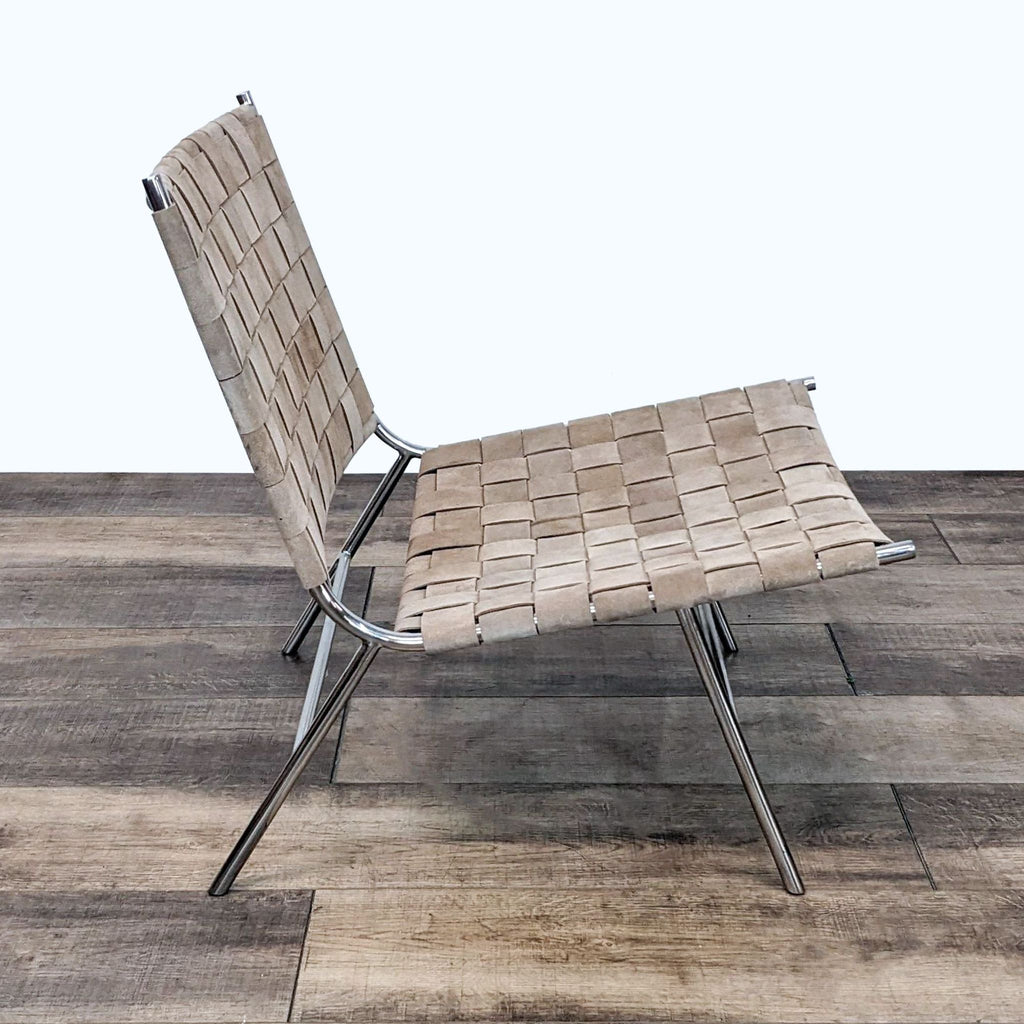 2. Mermelada Estudio's midcentury-style lounge chair with woven suede on a chrome frame, set on a wooden floor.