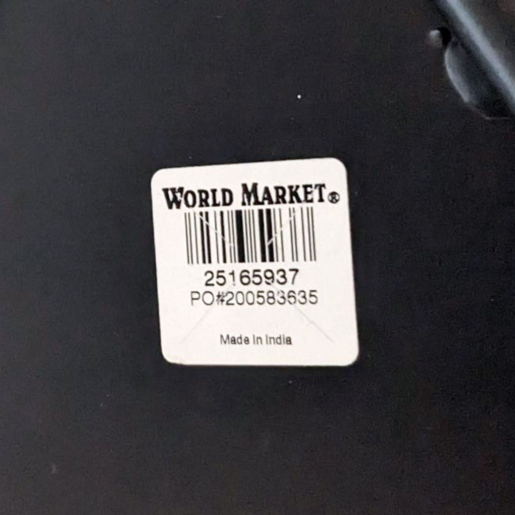 Label showing World Market brand and "Made in India" on the underside of a handcrafted side table with barcode.