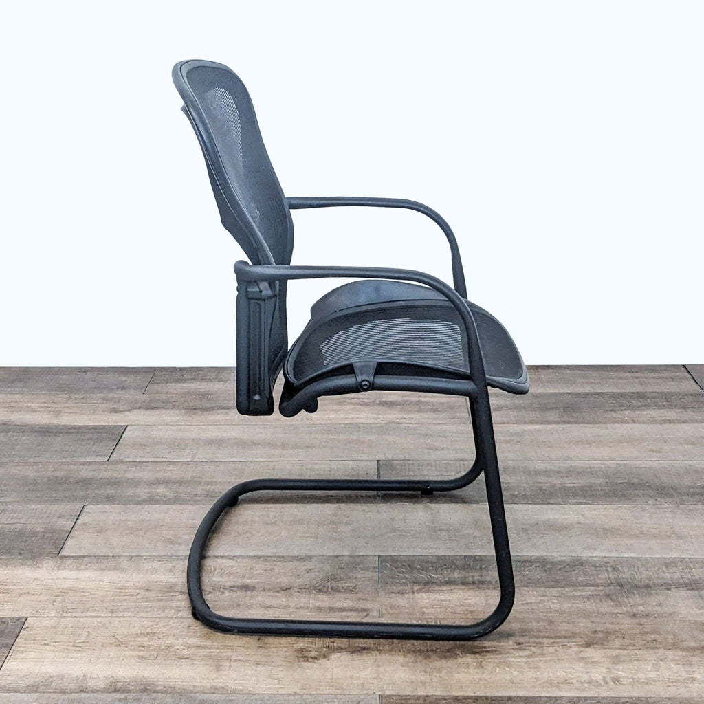 2. Side view of the iconic Herman Miller Aeron Side Chair displaying its ergonomic design and sled base on a wooden floor.