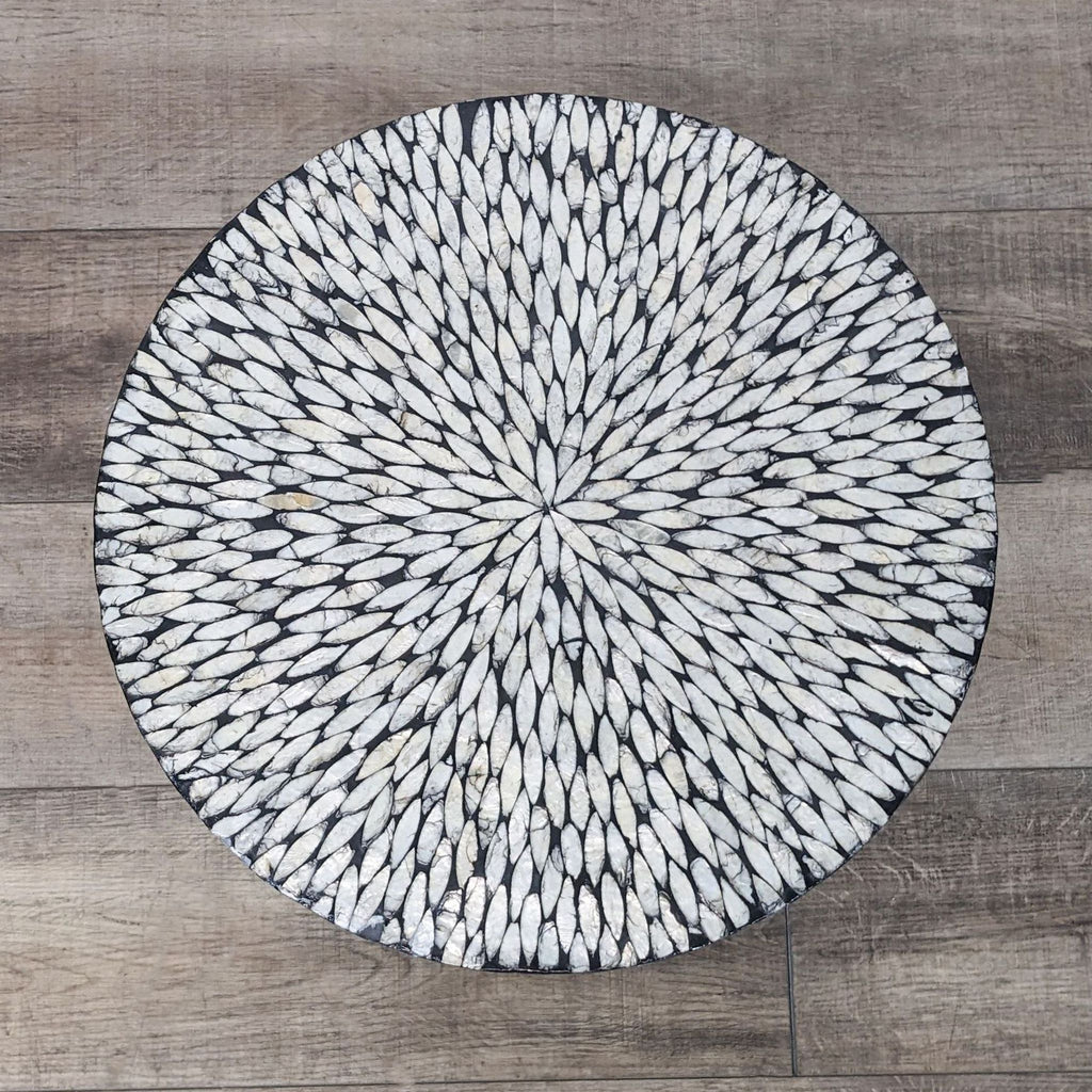 3. "Top view of a circular mosaic tabletop design from Reperch, depicting radial symmetry with white and gray tiles."