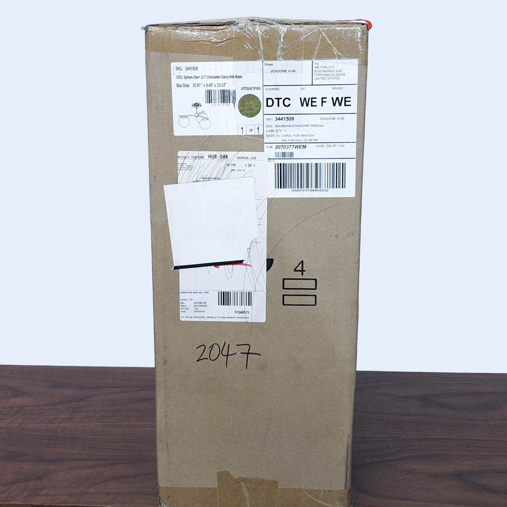 Cardboard shipping box for West Elm light fixture, with product label and image on the side.