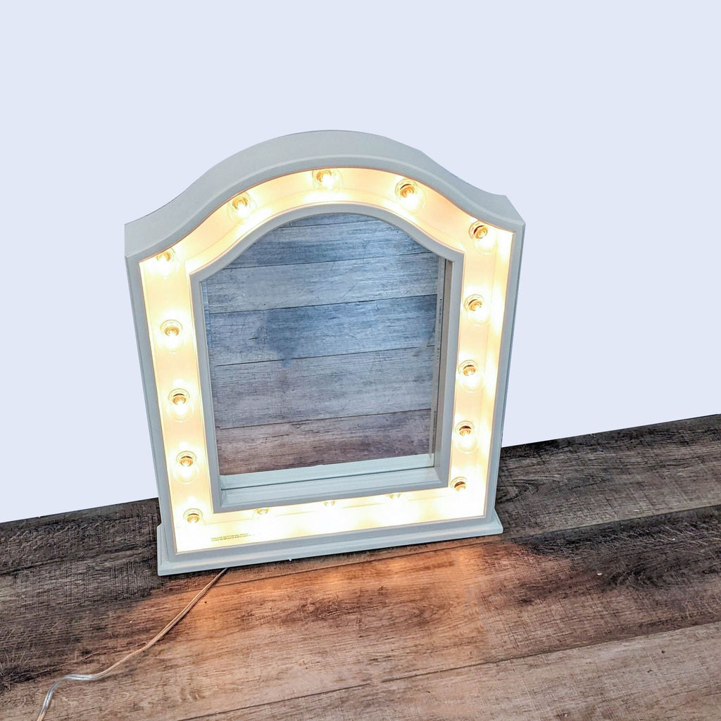 Pottery Barn Teen Hannah mirror with wooden arch frame and lit spherical bulbs on a wood surface.