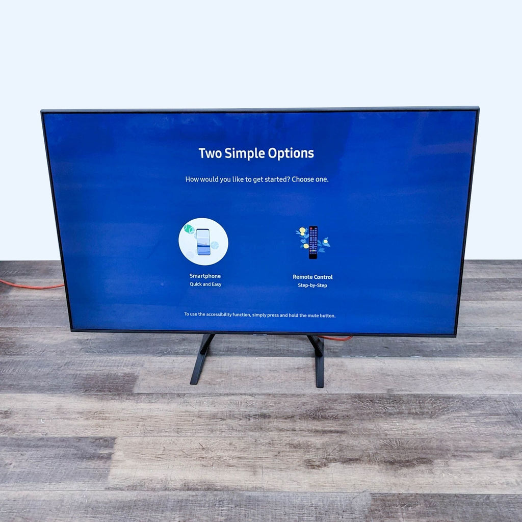 1. Samsung flat-screen TV on stand with initial setup screen displaying two options: Smartphone or Remote Control, exemplifying ease of use.