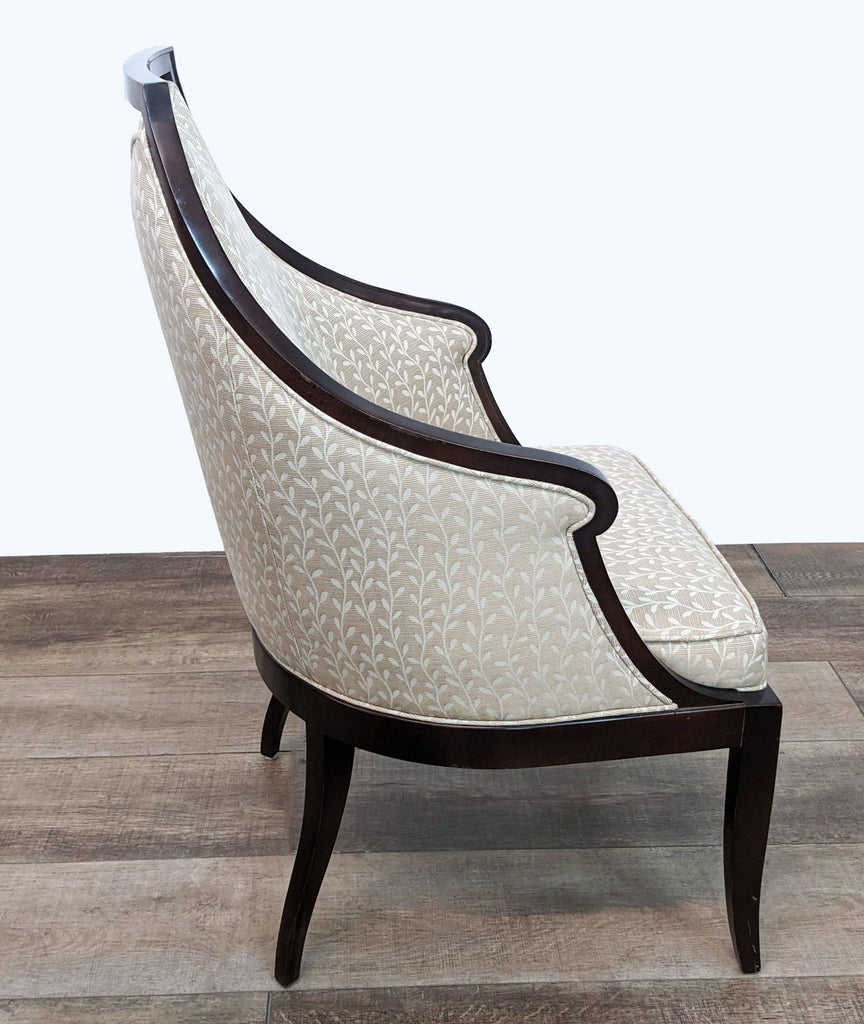 2. Side angle of a Baker lounge armchair in ivory fabric with detailed vine patterns, showcasing its elegantly curved back and wooden frame.