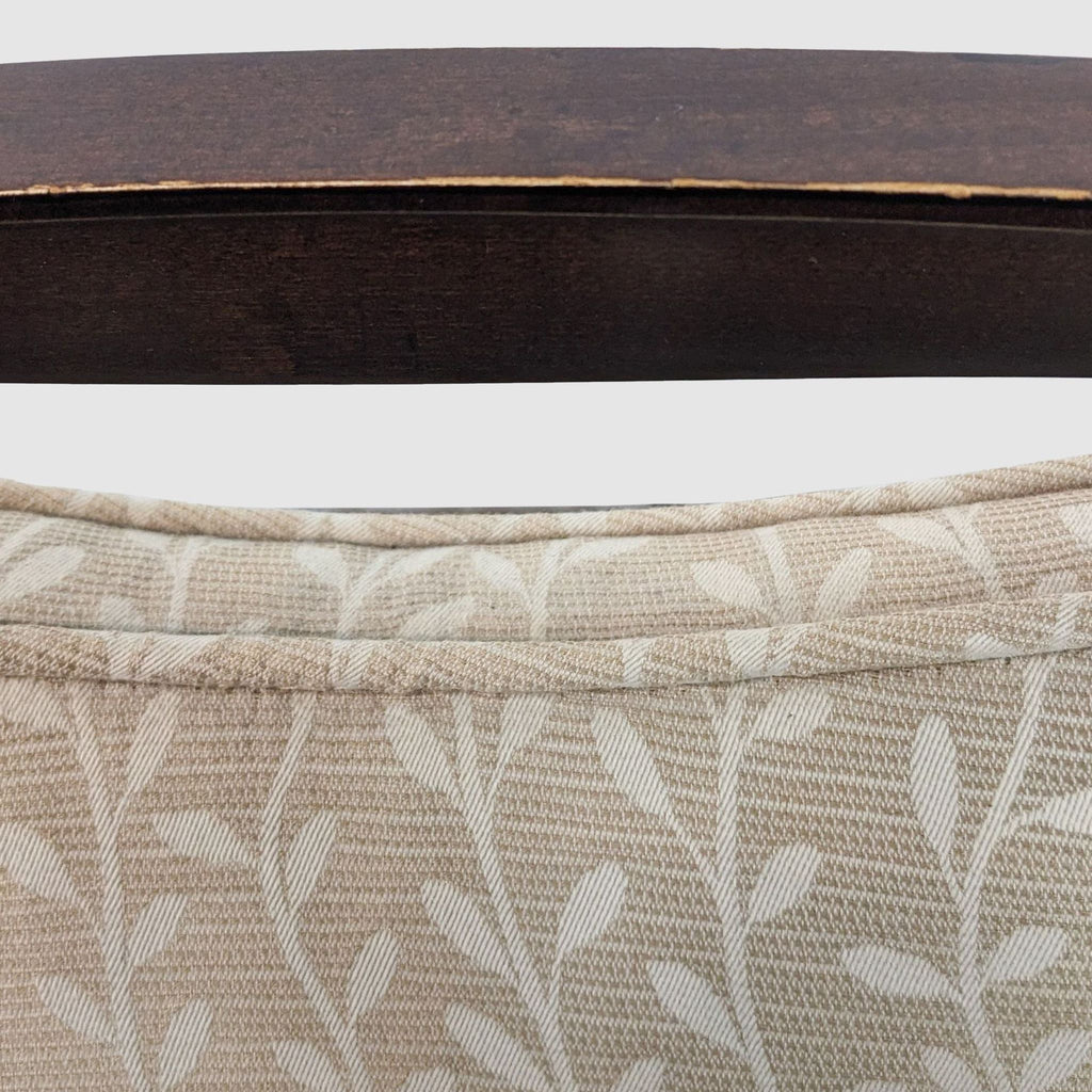 3. Close-up on the ivory chenille fabric with vine and leaf pattern and the textured seam on the upper backrest of a Baker Malmaison armchair.