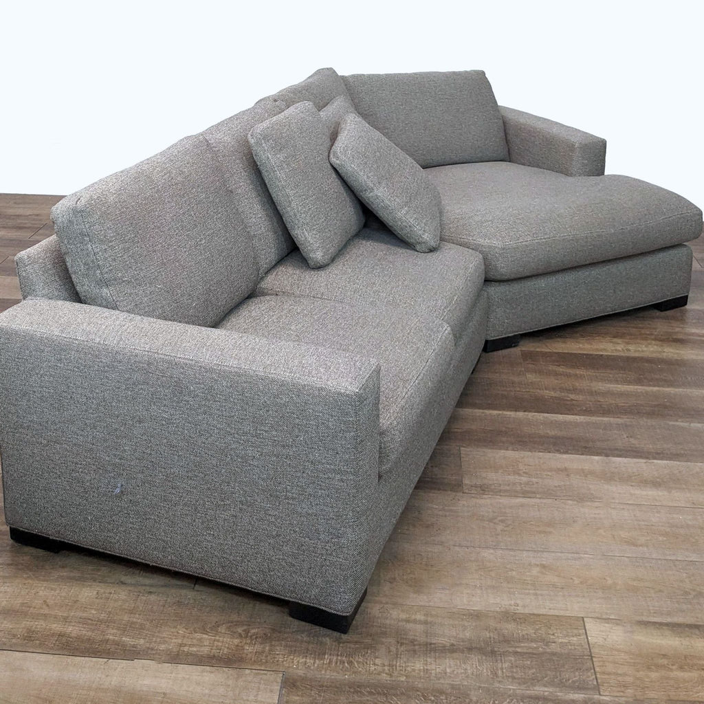 2. Angled view of a grey Room & Board Metro sectional sofa with removable deep cushions, showcasing the chaise section.