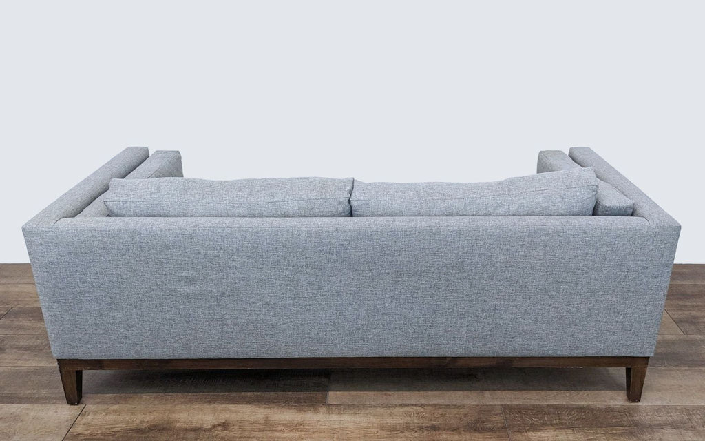 3. Back view of a Sofa Creations 3-seat sofa featuring durable heather gray fabric and robust wooden legs against a neutral backdrop.