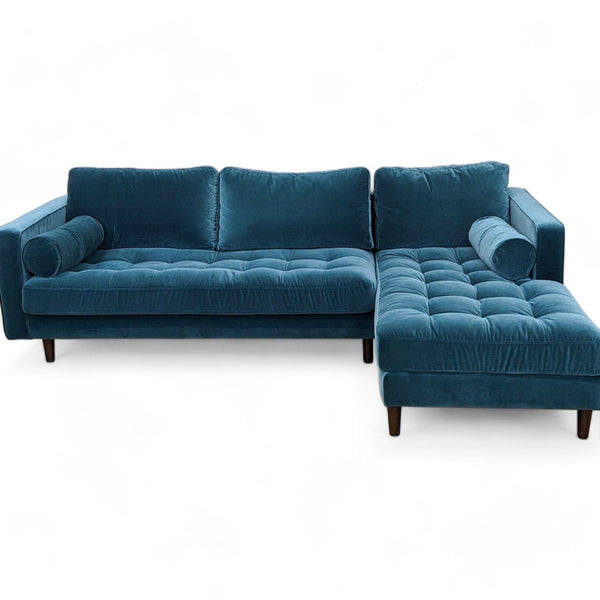 1. Sven sofa by Article with a modern mid-century design, tufted benchseat, and three back cushions in blue, isolated on white.