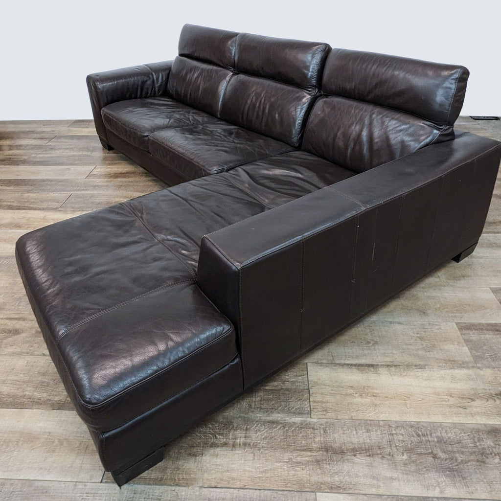 Chocolate brown leather L-shaped sofa by Reperch with adjustable headrests, showcasing side angle on wooden flooring.