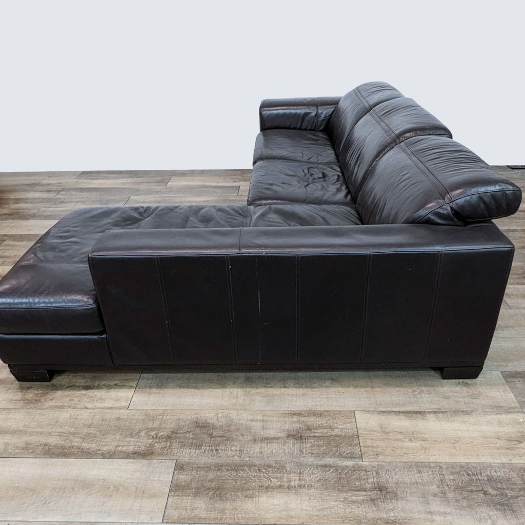 L-shaped sectional in chocolate brown leather with headrests by Reperch, displayed at a three-quarter angle on wooden floor.